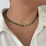 Necklace with 'LIBRA' pendant worn by a person in a white shirt